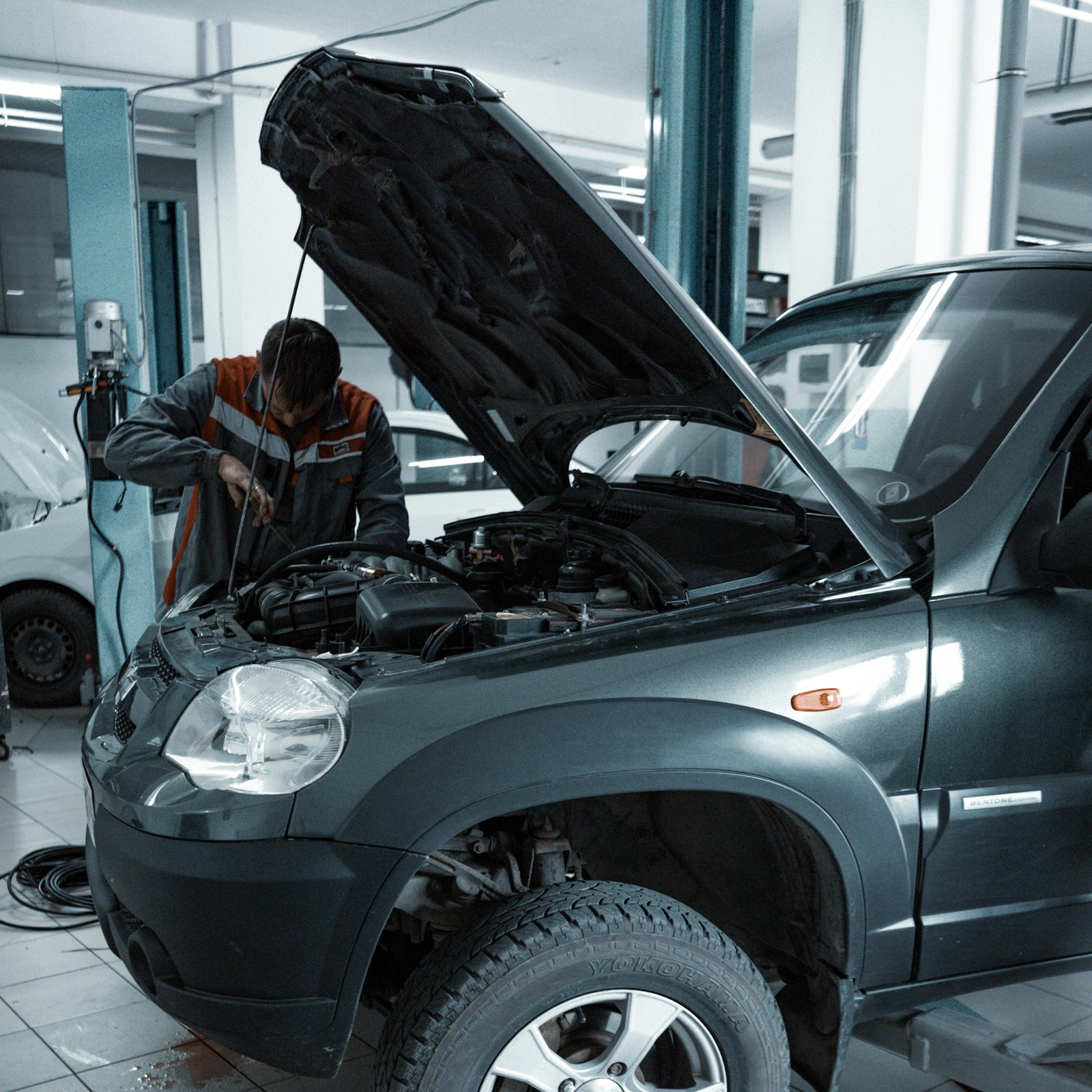 Technician working under the hood of a vehicle in the shop